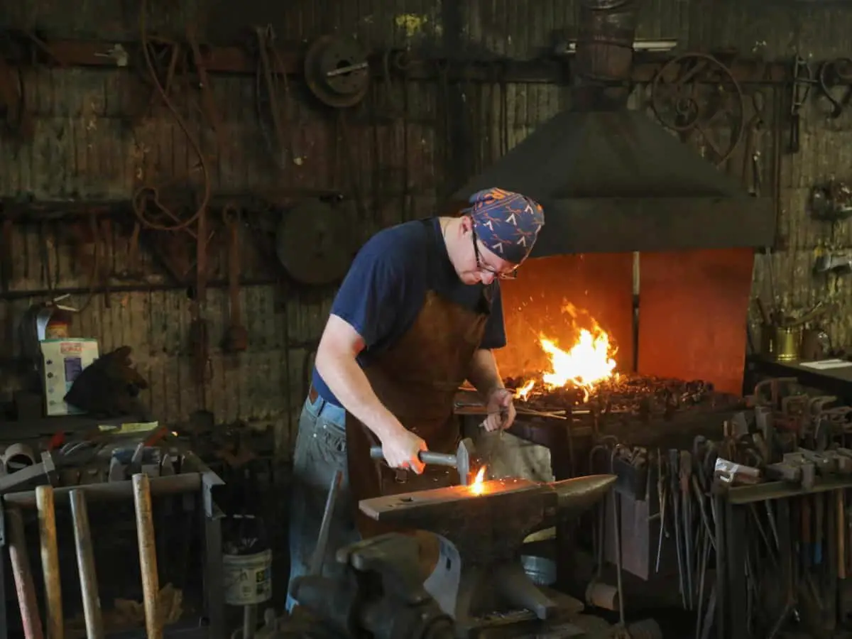 Person blacksmithing on an anvil.